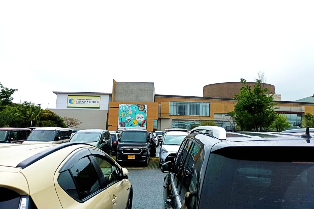 北九州市のいのちのたび博物館の外観。広い敷地の中に落ち着いた色合いの建物が建ち、旅の途中で立ち寄る「静かな知の入口」のような雰囲気を感じさせる。